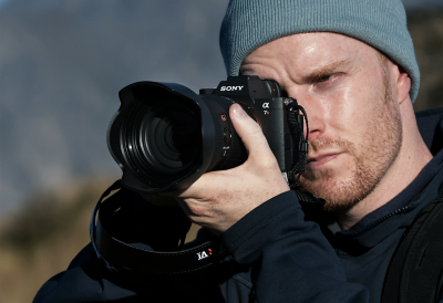 Imagen de uso de un fotógrafo sosteniendo la α7R VI en un entorno al aire libre.