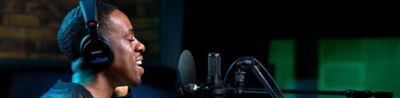 Kreator memproduksi audio di studio dengan headphone Sony