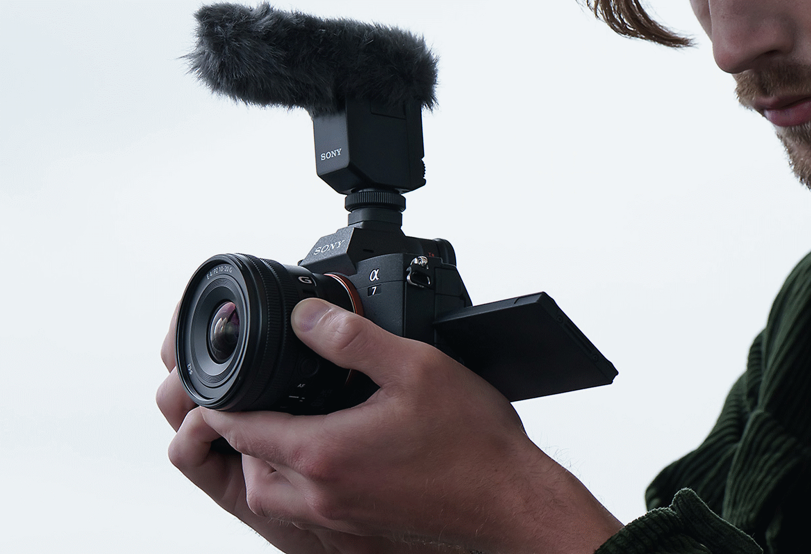 Image of a man recording a video clip while operating the E PZ 10–20 mm F4 G’s zoom lever