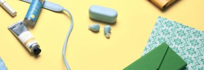 Écouteurs WF-C510 posés sur une table avec le boîtier bleu assorti et d'autres accessoires personnels