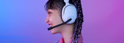 Side profile of a gamer wearing the INZONE H5 headphones with the microphone down and in use