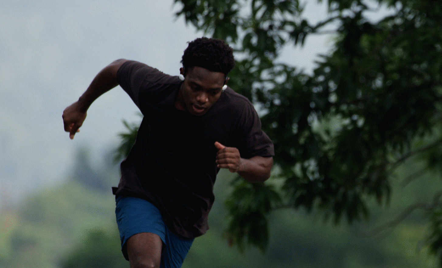 Imagen de un hombre corriendo en el bosque con los audífonos Sony Float Run
