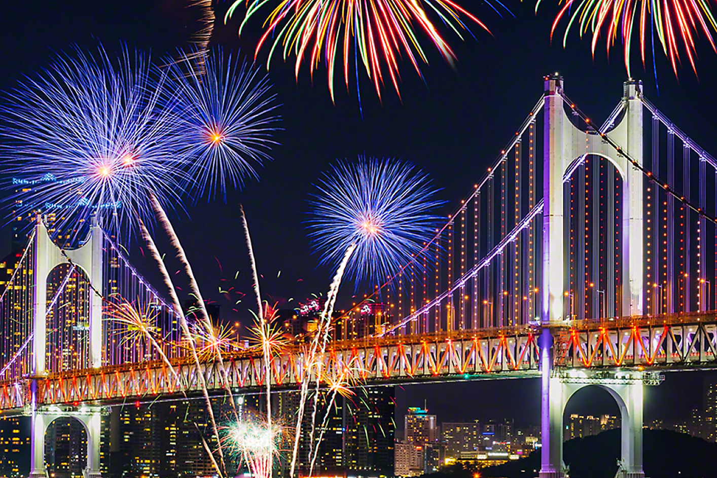 Colourful fireworks explode over a bridge