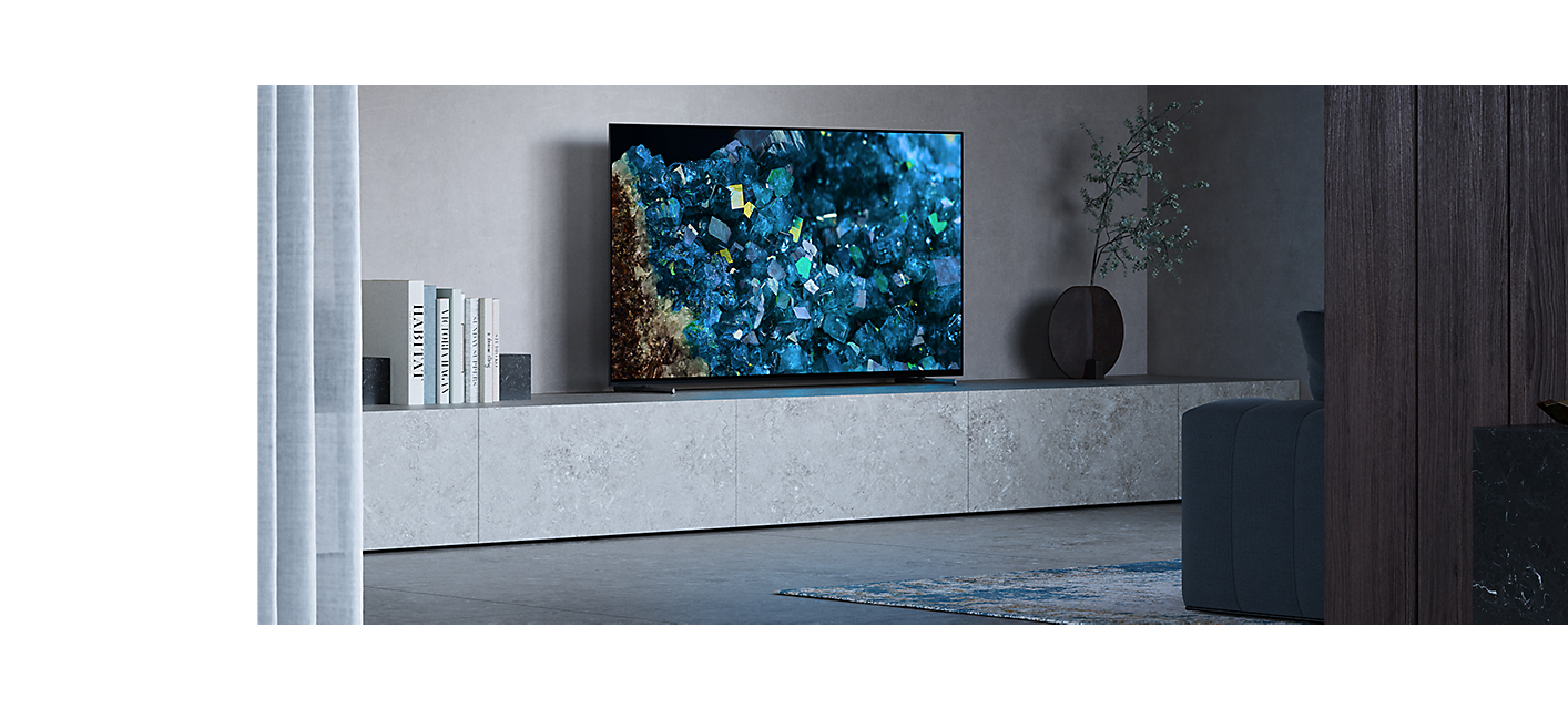 BRAVIA A80L/A83L/ A84L numa sala de estar com planta e livros ao lado da TV e cristais azuis no ecrã