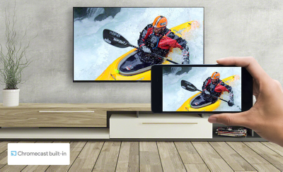 A hand holds a smartphone in front of a wall-mounted TV - both screens display the same kayaking image. A logo for Chromecast built-in sits on the bottom left.