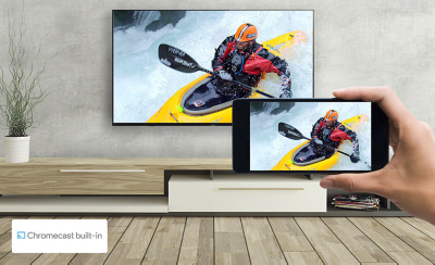 A hand holds a smartphone in front of a wall-mounted TV - both screens display the same kayaking image. A logo for Chromecast built-in sits on the bottom left.