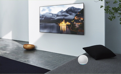 Image d'un salon avec un téléviseur sur le mur et un appareil Alexa sur le côté