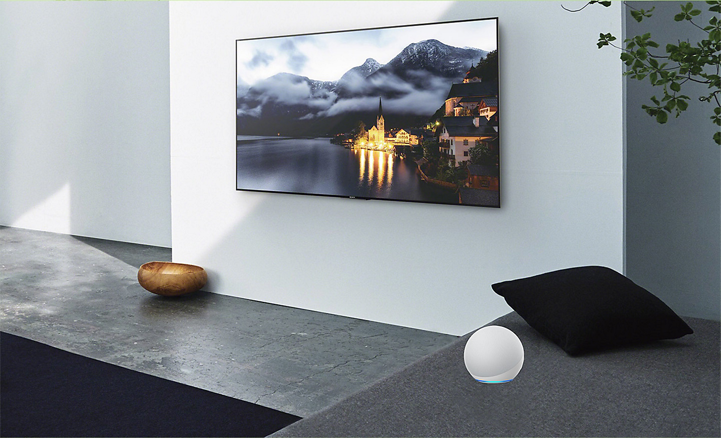 Escena de una sala de estar con una televisión en la pared y un dispositivo Alexa al lado
