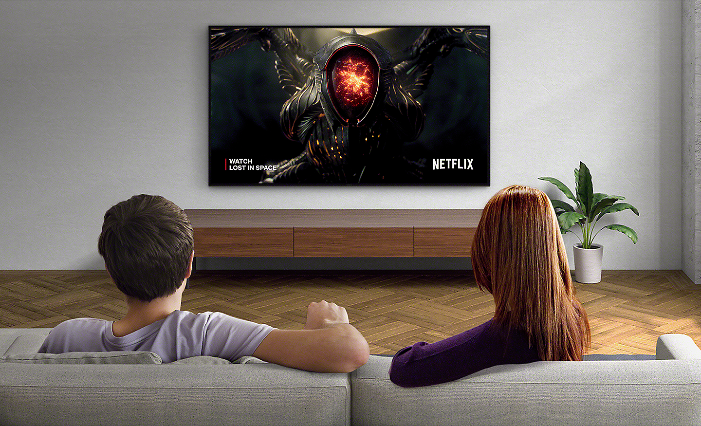 Gambar pasangan di ruang keluarga sedang menonton Netflix di BRAVIA TV yang terpasang di dinding