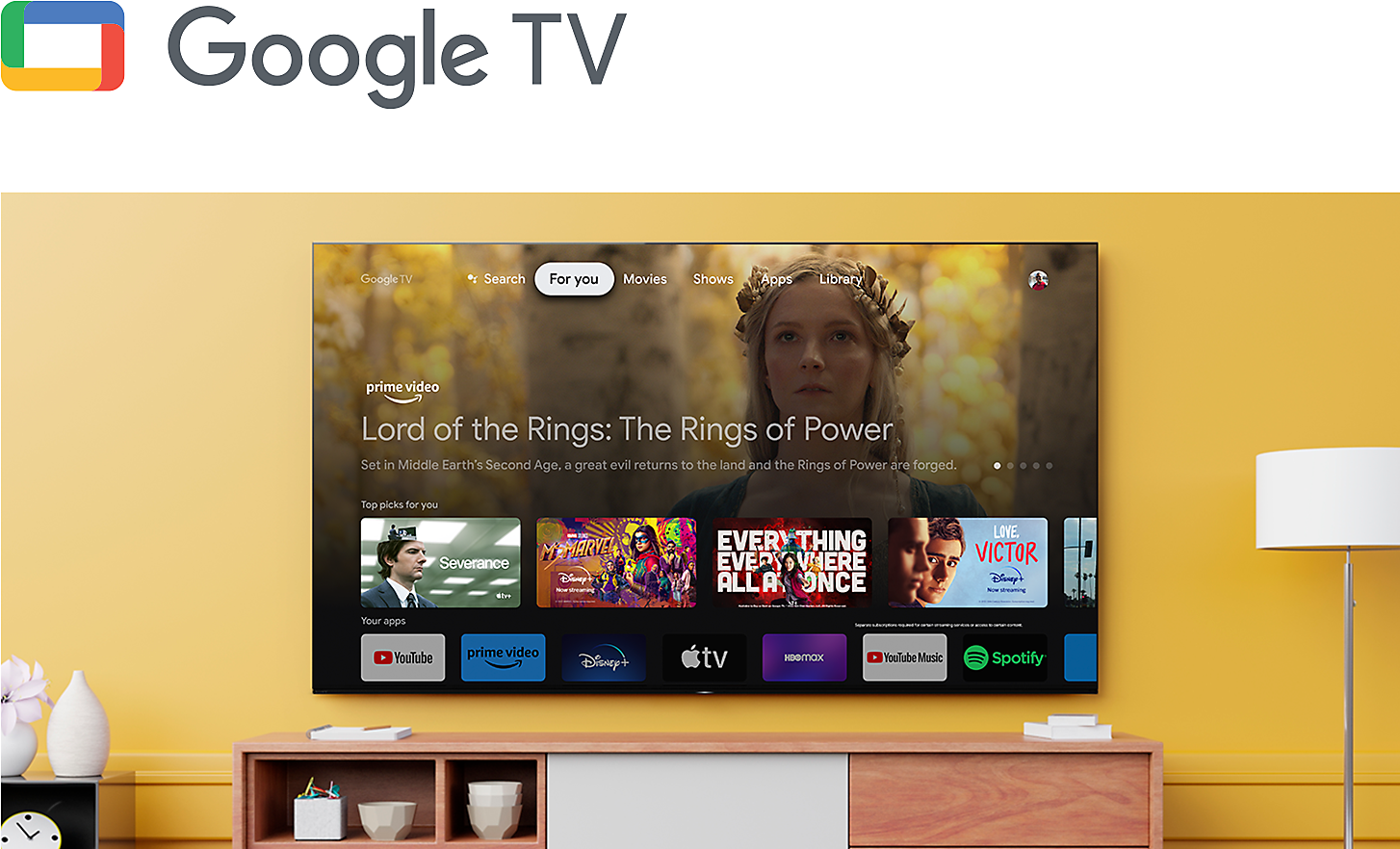 Logo for Google TV above a living room with a wall-mounted BRAVIA TV displaying an array of entertainment apps and streaming services