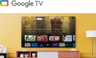 Logo for Google TV above a living room with a wall-mounted BRAVIA TV displaying an array of entertainment apps and streaming services