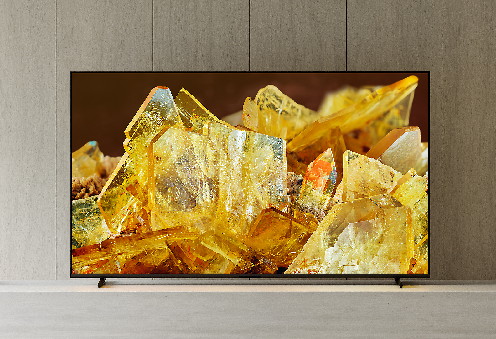 BRAVIA XR televízió egy nappaliban, a képernyőn közeli kép borostyánszínű kristályokról