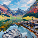 Image of a lake surrounded by mountains and trees with incredibly rich, vivid colours