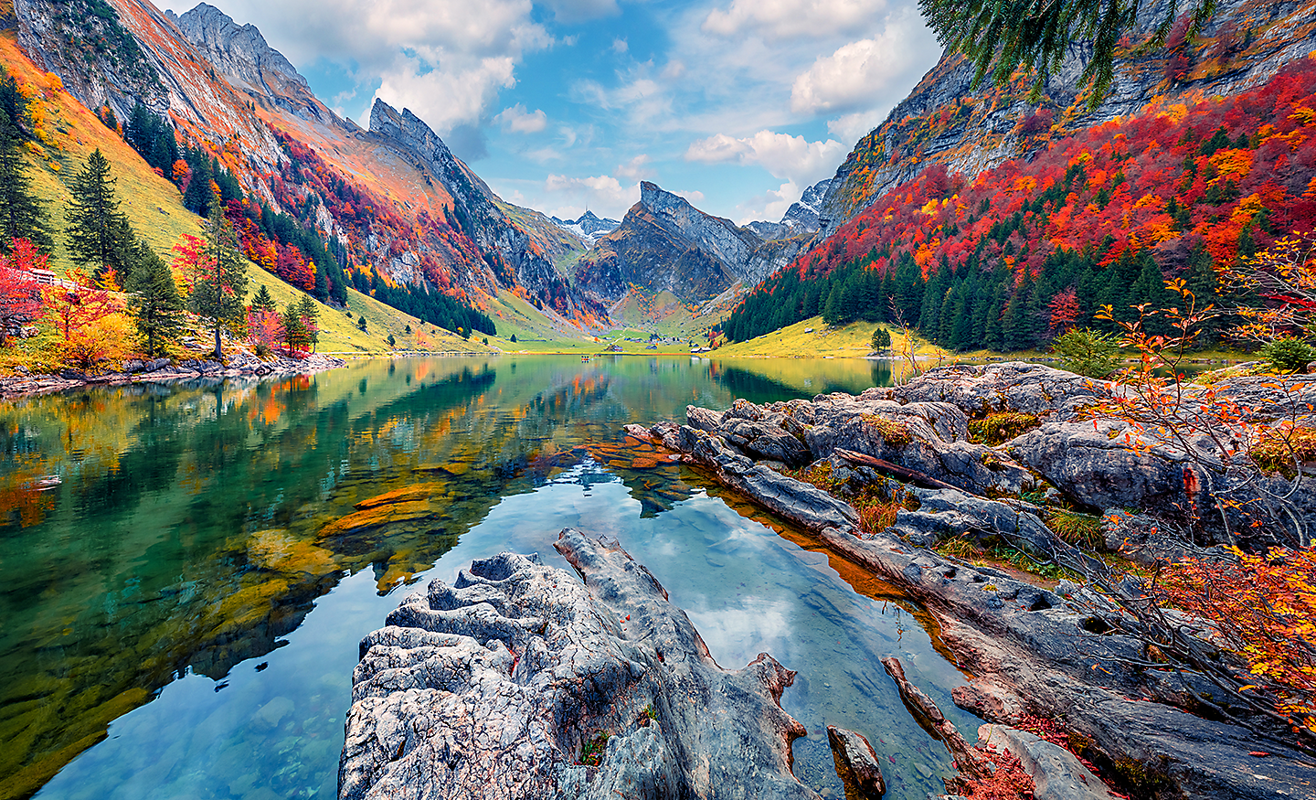 Gambar danau yang dikelilingi pegunungan dan pepohonan dengan warna yang sangat kaya dan hidup