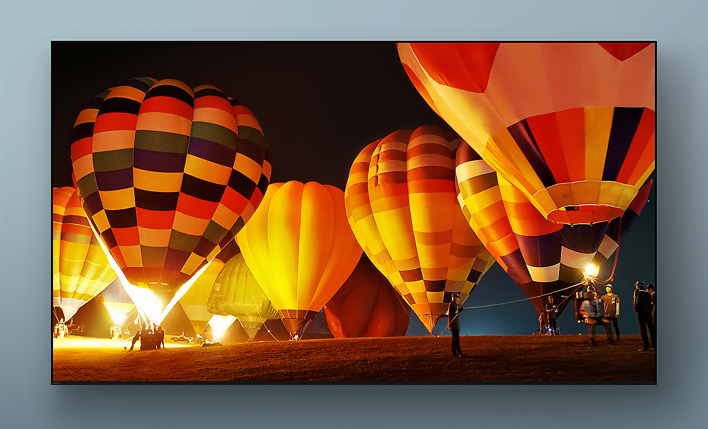 Televizor BRAVIA se snímkem obrazovky pestrobarevných horkovzdušných balónů startujících během noci