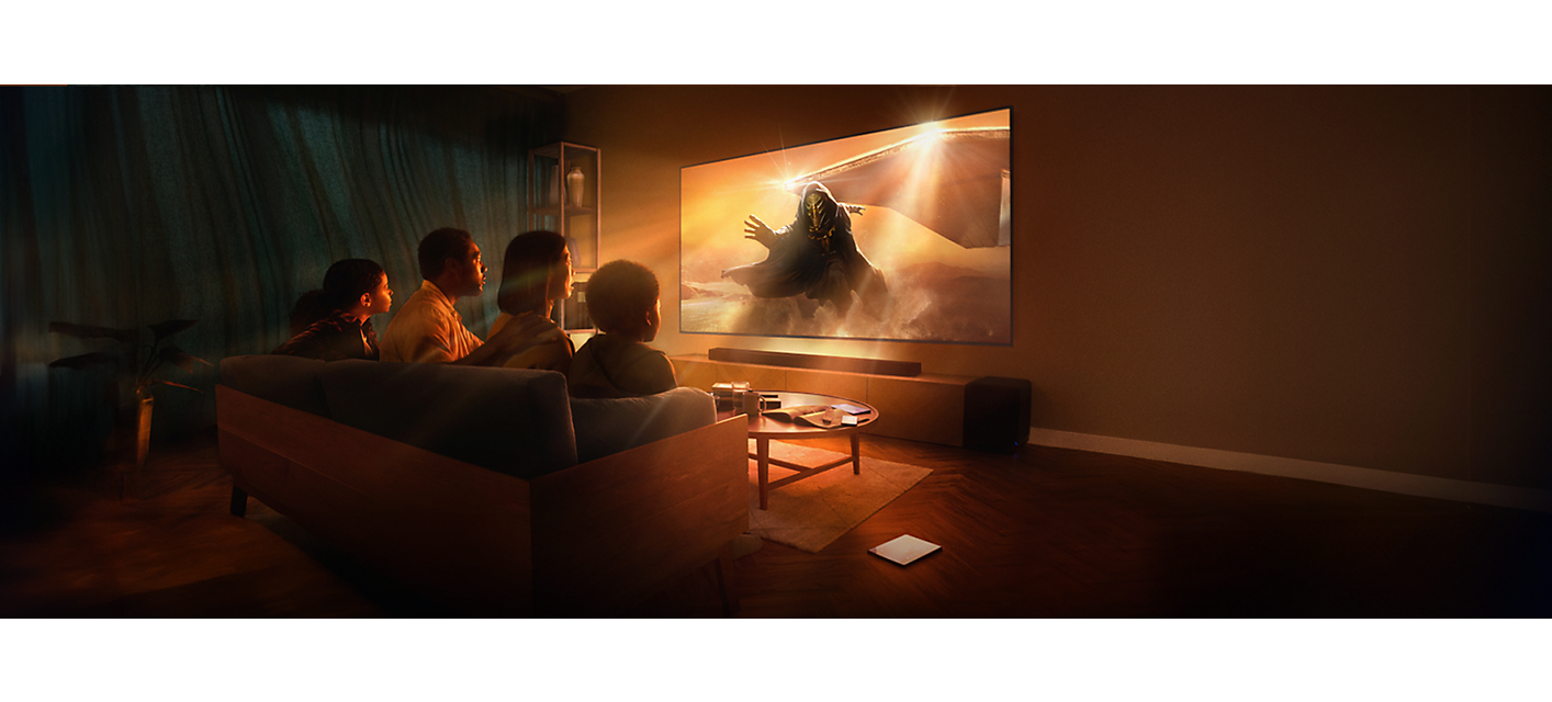 סצנת סלון עם שלושה אנשים שיושבים על ספה, טלוויזיה המותקנת על קיר ומקרן קול, עם צילום מסך של אסטרונאוט צועד דרך ערפל כתום.