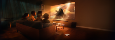 Living room scene with three people sitting on a sofa and wall-mounted TV and soundbar with screenshot of astronaut stepping through orange mist