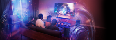 Living room scene with people sitting on a sofa and wall-mounted TV and soundbar with sound spheres showing 360 Spatial Sound Mapping