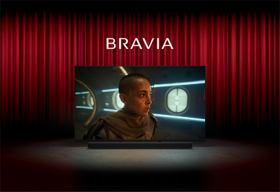 Image of a cinema with red curtains and Sony TV centre stage with screenshot of a person in a sci-fi movie, the word BRAVIA above and Sony soundbar below