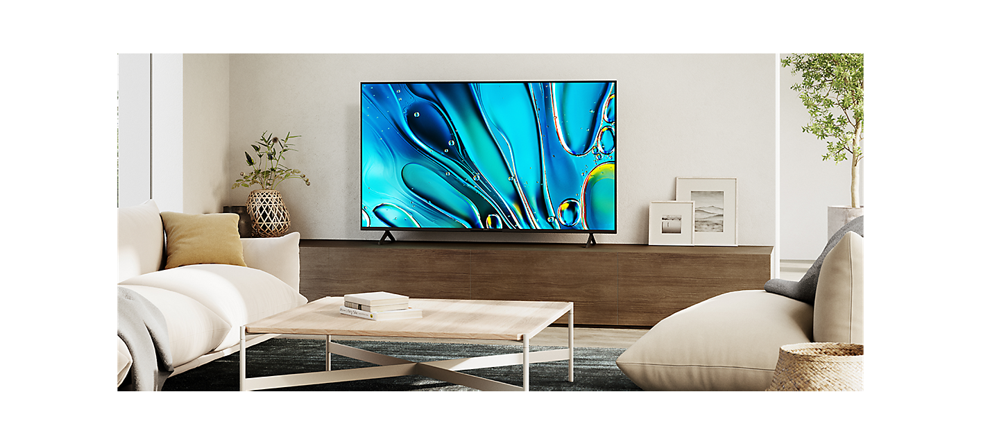 Living room scene with coffee table centre and TV on a large wooden cabinet with screenshot of blue water droplets