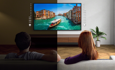 Écran partagé avec l'image de deux personnes assises sur un canapé et regardant une TV au mur montrant la capture d'écran d'une gondole à Venise : la personne assise à gauche est dans une pièce sombre, la personne à droite dans une pièce claire