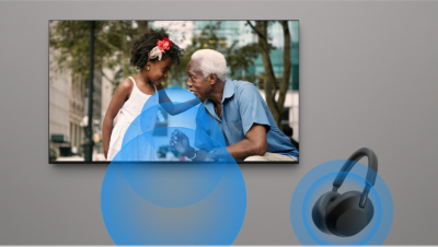 Televizor montat pe perete, deasupra unei bare de sunet, cu imagine cu doua persoane vorbind, cu o scena urbana pe fundal si pictogramele de meniu in partea de jos a ecranului