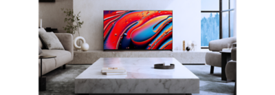 Living room scene with coffee table centre and TV on a plinth with ornaments to side and screenshot of red and blue water droplets