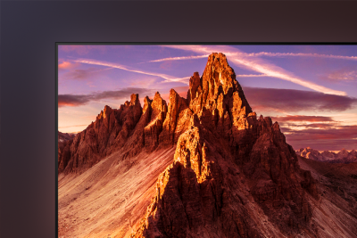 Detail of top left corner of TV showing screenshot of jagged mountains at sunrise