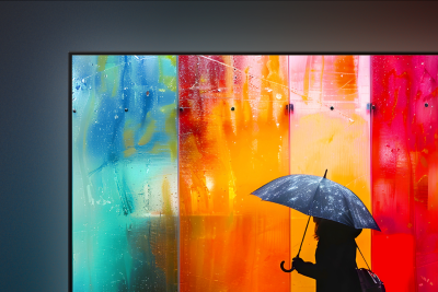 TV screen displaying a person with an umbrella in front of a vibrant, multi-coloured backdrop.