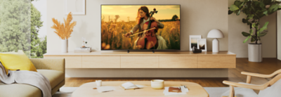 BRAVIA 5-TV som viser en musiker som spiller cello i en gyllen eng, plassert i en moderne stue.