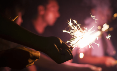 Personas sosteniendo bengalas, con áreas de brillo y oscuridad en contraste, lo que muestra el rango de luz en una pantalla.