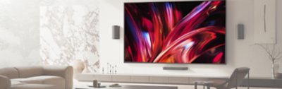 Un televisor con un soporte para instalación en pared de un salón moderno y luminoso, en el que se muestra una escena cinematográfica en primer plano en pantalla.