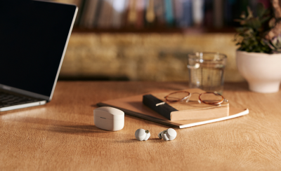 장식된 목재 책상 위 케이스 옆에 놓여진 화이트 WF-1000XM4 한 쌍