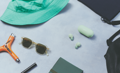 灰綠色 WF-C700N 耳塞式耳機和充電盒平放，以及夏日配件