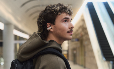 Một người đang đeo tai nghe LinkBuds Clip và đi bộ qua ga tàu