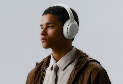 Sofisticirani urbani portret mladića koji nosi platinasto srebrne slušalice Sony WH-1000XM4C