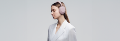 Žena s nasazenými sluchátky WH-1000XM6 v pískově růžové barvě