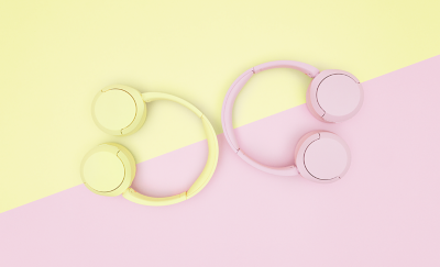 Deux casques Sony WH-CH520 de couleur jaune et rose sur un arrière-plan pastel bicolore.