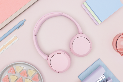Un casque Sony WH-CH520 rose posé sur un bureau pastel.