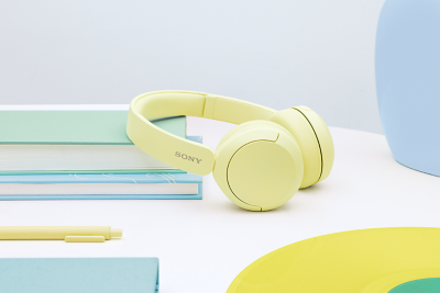 Un casque Sony WH-CH520 jaune posé sur un bureau.