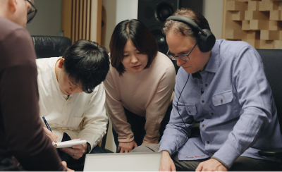 노트북에서 토토사이트 운영자 검거를 검토하고 메모하는 오디오 엔지니어들.