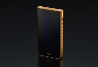 Gold Sony Walkman with black screen on dark background.
