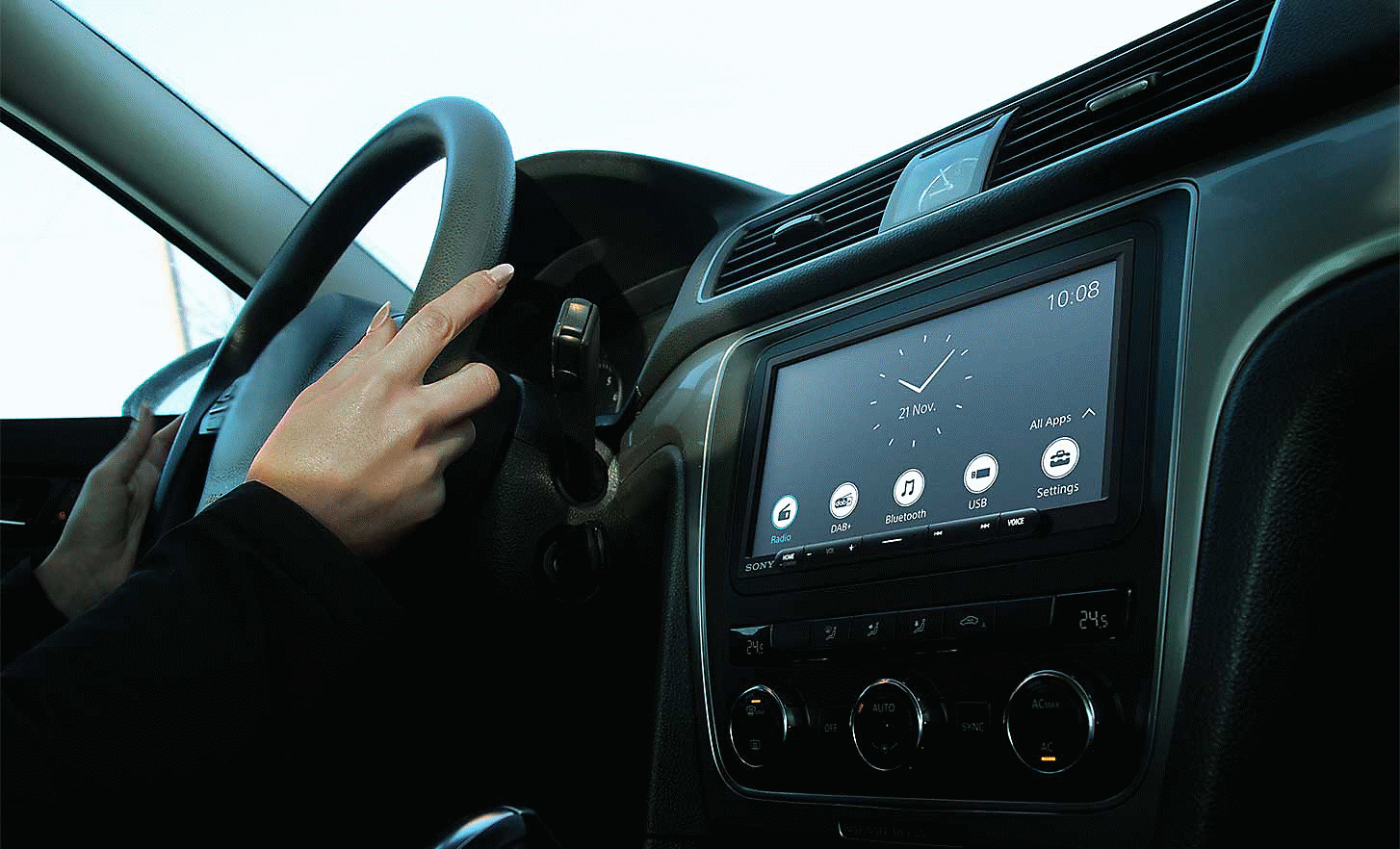 Image du XAV-AX4050 sur le tableau de bord d'une voiture avec une horloge et divers boutons à l'écran