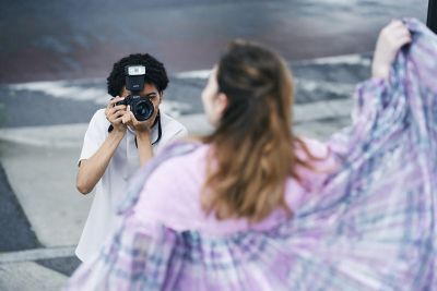 Un hombre captando un retrato al aire libre con el modo de captura continua con flash