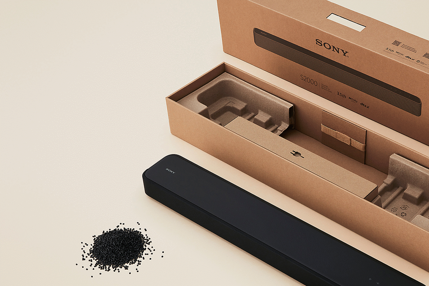 Image of a soundbar, its paper packaging materials and a pile of plastic pellets.