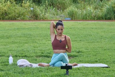 Hình ảnh sử dụng cho thấy một phụ nữ đang đeo micro và tập yoga với bộ thu được gắn trên máy ảnh gần đó