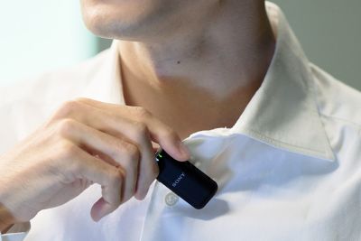 Hình ảnh sử dụng thể hiện một người đàn ông đang gắn micro vào áo của mình