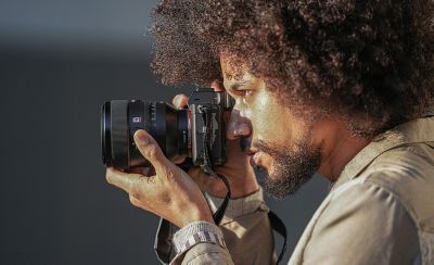Slika osobe koja drži fotoaparat s objektivom FE 50 mm F1,2 GM