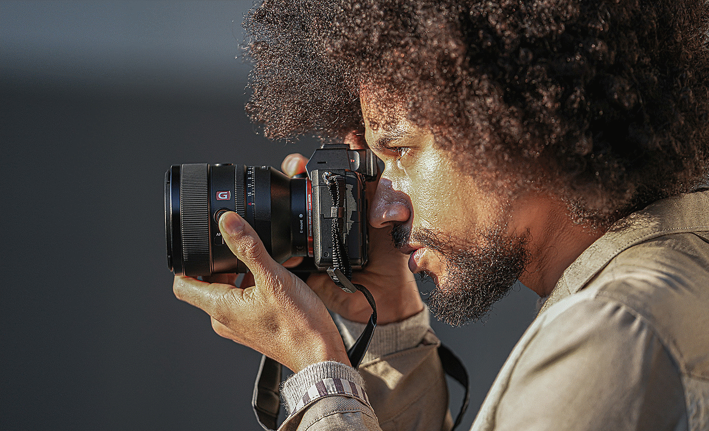 Bilde av en person som holder et kamera med FE 50mm F1.2 GM-objektivet montert