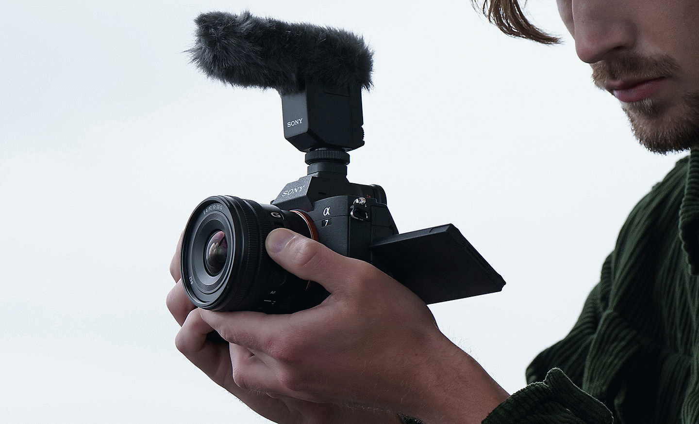 Gambar seorang pria merekam klip video sambil mengoperasikan tuas zoom E PZ 10-20mm F4 G